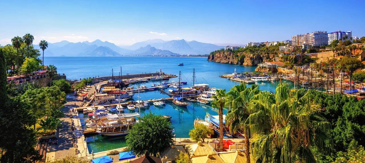 Panorama of Antalya's old harbour with boats below the cliffs of Kaleiçi